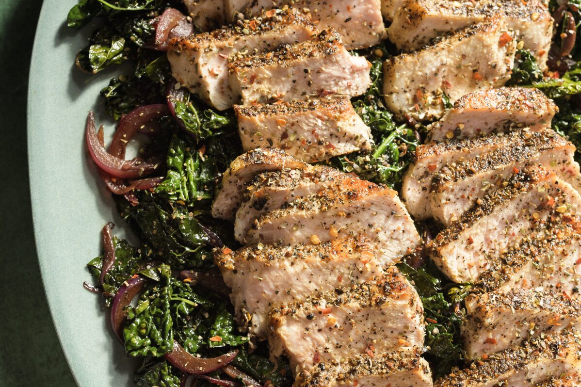This image released by Milk Street shows a recipe for pork with kale, red wine and toasted garlic. (Milk Street via AP)
