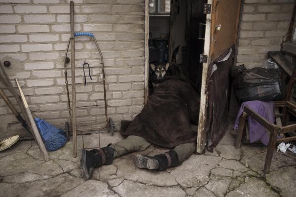 FILE - A dog stands next to the body of an elderly woman killed at the entrance of her house in Bucha, outskirts of Kyiv, Ukraine, Tuesday, April 5, 2022. (AP Photo/Felipe Dana, File)