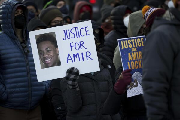 A protester holds a sign demanding justice for Amir Locke at a rally on Saturday, Feb. 5, 2022, in Minneapolis. Hundreds of people filled the streets of downtown Minneapolis after body cam footage released by the Minneapolis Police Department showed an officer shoot and kill Locke during a no-knock warrant. (AP Photo/Christian Monterrosa)