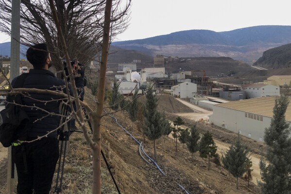 Journalists work next to the Copler gold mine near Ilic village, east Turkey, Tuesday, Feb. 13, 2024. A landslide hit a gold mine in eastern Turkey on Tuesday, apparently trapping at least nine workers underground, officials said. (IHA via AP)