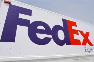 FILE - The FedEx logo is seen on a delivery truck Tuesday, June 21, 2011, in Springfield, Ill. FedEx said Thursday, Sept. 15, 2022, that it is shuttering storefronts and corporate offices while putting off new hires in a belt-tightening drive brought on by drop-off in its global package delivery business. (AP Photo/Seth Perlman, File)