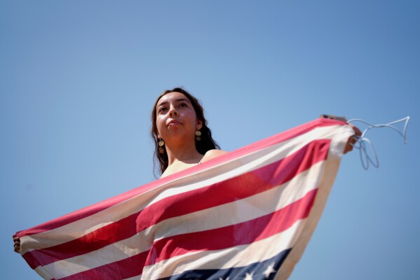 A protester holds a U.S. flag upside down, Monday, June 9, 2025, in downtown Los Angeles. (AP Photo/Eric Thayer)