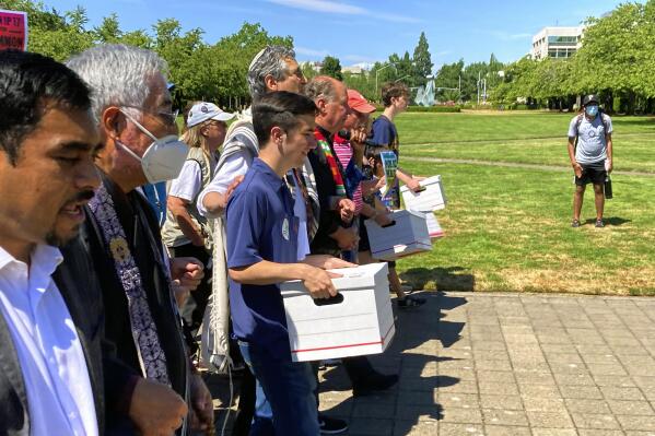 FILE - Backers of a proposed initiative that would require individuals to secure permits to buy firearms and ban large-capacity magazines deliver the signatures of thousands of voters on July 8, 2022, to state election offices in Salem, Ore. (AP Photo/Andrew Selsky, file)