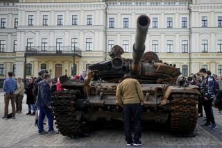FILE - A man looks at a destroyed Russian tank placed as a symbol of war in downtown Kyiv, Ukraine, May 23, 2022. A new report from NewsGuard, a tech firm that tracks disinformation has identified 250 websites actively working to spread Kremlin disinformation.(AP Photo/Natacha Pisarenko, File)