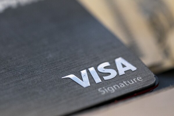 FILE - This Aug. 11, 2019, file photo shows a Visa logo on a credit card in New Orleans. Visa reports earnings on Tuesday, Oct. 24, 2023. (AP Photo/Jenny Kane, File)