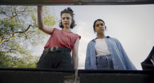 This image released by Focus Features shows Geraldine Viswanathan, right, and Margaret Qualley in a scene from "Drive-Away Girls." (Focus Features via AP)