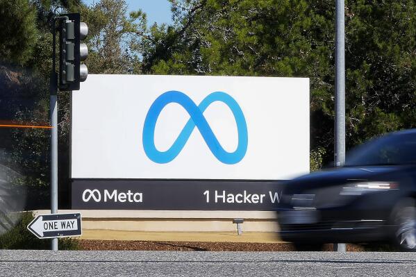 FILE - A car passes Facebook's new Meta logo on a sign at the company headquarters on Oct. 28, 2021, in Menlo Park, Calif. Facebook parent Meta unveiled a high-end virtual reality headset Tuesday, Oct. 12, 2022, with the hope that people will soon be using it to work and play in the still-elusive place called the “metaverse." (AP Photo/Tony Avelar, File)