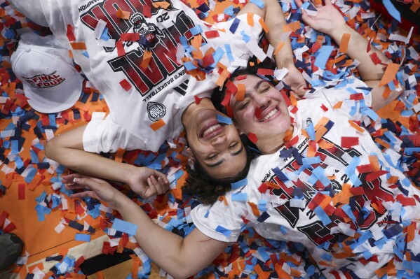North Carolina State guard Madison Hayes, left, and forward Mimi Collins celebrate after the Elite Eight college basketball game in the women's NCAA Tournament, Sunday, March 31, 2024, in Portland, Ore. (AP Photo/Howard Lao)