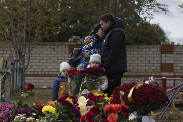 FILE - People react near the memorial for the victims of a Russian rocket attack in the village of Hroza near Kharkiv, Ukraine, Sunday, Oct. 8, 2023. A report by U.N investigators has pointed a finger at Russia as likely being responsible for the deaths of 59 civilians at a village café hit by a missile in eastern Ukraine in early October, in what was one of the deadliest strikes since the Kremlin’s forces launched a full-scale invasion 20 months ago. (AP Photo/Alex Babenko, File)