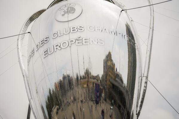 Pedestrians are reflected in a giant Champions League trophy shaped balloon placed at Taksim square in Istanbul, Turkey, Thursday, June 8, 2023. Manchester City will play Inter Milan in the final of the Champions League on Saturday June 10 in Istanbul. (AP Photo/Francisco Seco)