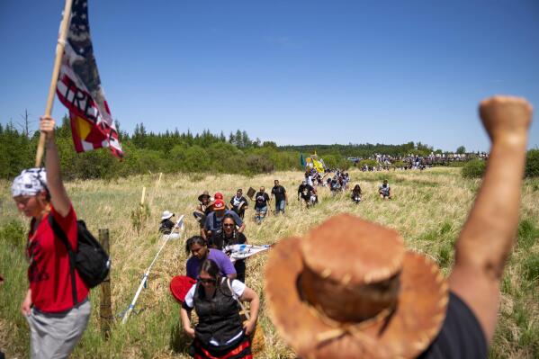 FILE - Indigenous leaders and "water protectors" march through swamp land to the boardwalk leading to an Enbridge pipeline construction site, June 7, 2021, in Clearwater County, Minn. The Biden administration on Thursday, June 2, 2022, proposed undoing a Trump-era rule that limited the power of states and Native American tribes to block energy projects like natural gas pipelines based on their potential to pollute rivers and streams. (Alex Kormann/Star Tribune via AP, File)