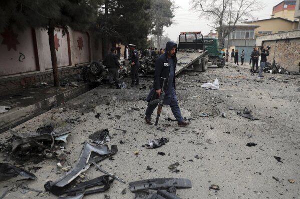 Security personnel inspect the site of a bomb attack in Kabul, Afghanistan, Saturday, Feb. 20, 2021. Three separate explosions in the capital Kabul on Saturday killed and wounded numerous people an Afghan official said. (AP Photo/Rahmat Gul)