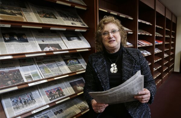 
              Penelope Muse Abernathy, a University of North Carolina professor, stands with the daily newspaper selection in the Park Library at the School of Journalism in Chapel Hill, N.C., on Thursday, March 7, 2019. "Strong newspapers have been good for democracy, and both educators and informers of a citizenry and its governing officials. They have been problem-solvers," said Abernathy, who studies news industry trends and oversaw the "news desert" report released the previous fall. (AP Photo/Gerry Broome)
            