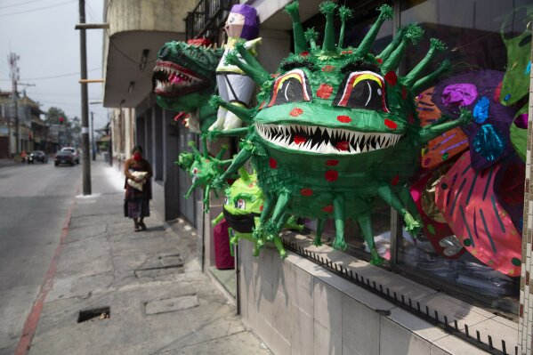 Piñatas depicting the new coronavirus are displayed in a store at Colon park in Guatemala City, Tuesday, April 14, 2020. The piñatas sell for about $1.50 depending on size. (AP Photo/Moises Castillo)