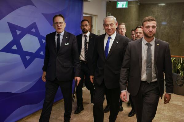 Israeli Prime Minister Benjamin Netanyahu, center, arrives for a weekly cabinet meeting at the Prime Minister's office in Jerusalem on Sunday, Jan. 15, 2023. (Menahem Kahana/Pool Photo via AP)