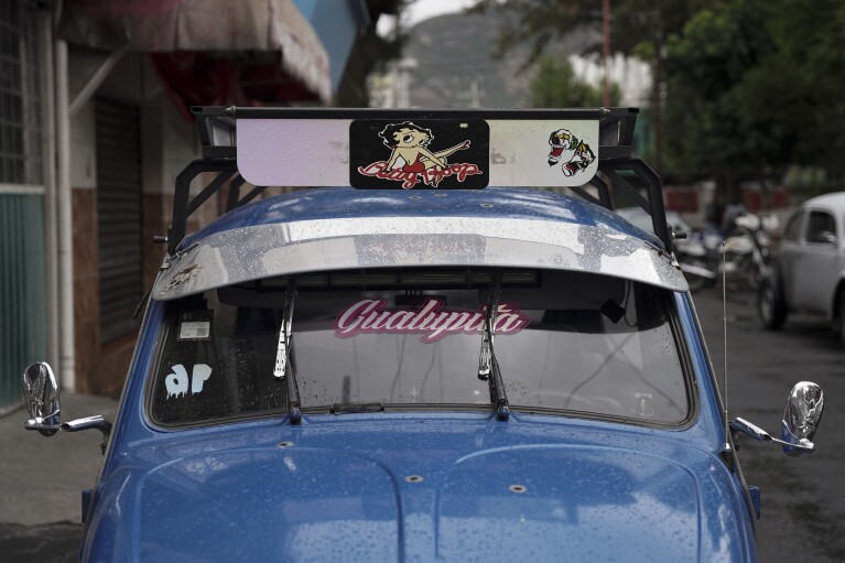 The bright blue Volkswagen Beetle owned by taxi driver Claudio Garcia he named "Gualupita" as his wife sits parked in the Cuautepec neighborhood of Mexico City, Friday, June 21, 2024. As some of the older Beetles rock together, paint long faded from years of wear and tear, other drivers like Garcia dress up the cars theirs, keeping them in top shape.  (AP Photo/Aurea Del Rosario)
