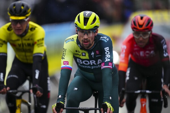 FILE - Slovenia's Primoz Roglic crosses the finish line during the sixth stage of the Paris-Nice cycling race in La Colle-sur-Loup, outside Nice, on March 8, 2024. Tour de France favorites Remco Evenepoel and Primoz Roglic were caught up in a massive crash Thursday June 6, 2024 at the Criterium du Dauphine race that led organizers to neutralize the stage. (AP Photo/Daniel Cole, File)