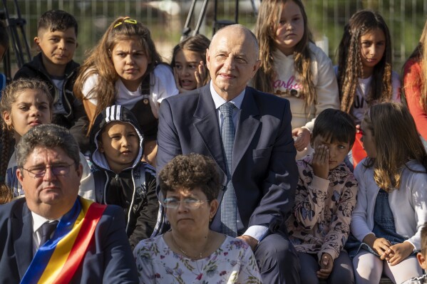 NATO Deputy Secretary General Mircea Geoana sits with children during a school opening ceremony in Ghergani, Romania, Monday, Sept. 11, 2023. According to Eurostat, in 2022 Romania had the highest percentage of early school leavers in the European union with 16 percent of youngsters between the ages of 18 and 24 abandoning education. (AP Photo/Vadim Ghirda)