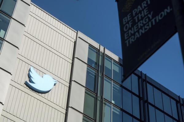 FILE - A Twitter logo hangs outside the company's San Francisco offices on Nov. 1, 2022. A top European Union official warned Elon Musk on Wednesday Nov. 30, 2022 that Twitter needs to beef up measures to protect users from hate speech, misinformation and other harmful content to avoid violating new rules that threaten tech giants with big fines or even a ban in the 27-nation bloc. (AP Photo/Noah Berger, File)