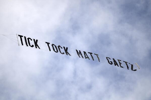 FILE - A banner reading "Tick Tock Matt Gaetz" is flown above the federal courthouse during a hearing for Joel Greenberg, on May 17, 2021, in Orlando, Fla. Sentencing for a former Florida tax collector whose arrest led to a probe of U.S. Rep. Matt Gaetz has been set for December 2022, as his lawyer indicated that his client continues to cooperate with federal investigators in Florida, the District of Columbia and other jurisdictions. (AP Photo/Phelan M. Ebenhack, File)