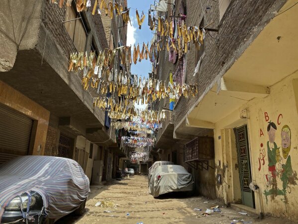 This April 17, 2020 photo, shows the street where 73-year-old Ghaliya Abdel-Wahab died from COVID-19 on April 6, 2020, on one of two streets on complete lockdown closed off by security forces for people to quarantine after her death, in Bahtim, Shubra el-Kheima neighborhood, Qalyoubiya governorate, Egypt. (AP Photo/Nariman El-Mofty)