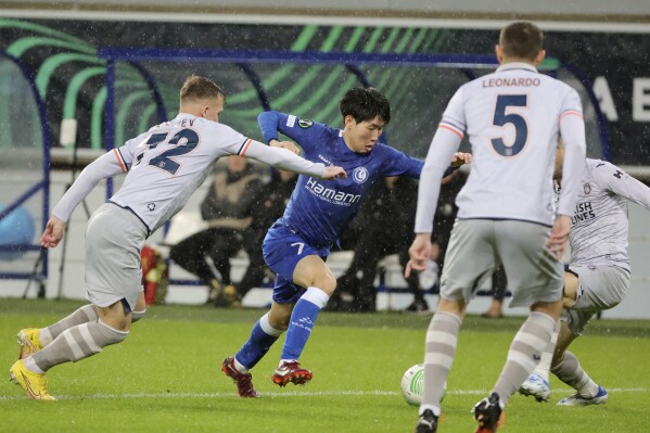 FILE - Istanbul Basaksehir's Eden Karzev, left, fights for the ball with Gent's Hyunseok Hong, center, during the Europa Conference League round of 16 first leg soccer match between Gent and Istanbul Basaksehir at KAA Gent stadium in Ghent, Belgium, Thursday, March 9, 2023. Turkish top-flight soccer club Basaksehir announced Thursday that it was parting ways with its Israeli player, Eden Karzev, following a disciplinary probe launched into a social media post that called for the release of hostages held by the Hamas militant group. (AP Photo/Olivier Matthys, File)