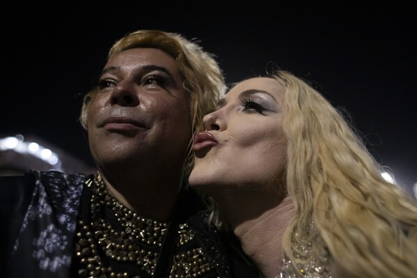 Performer Rinnaldy Borba, dressed as Madonna, poses for a selfie with a fan during a rehearsal for Madonna's Celebration tour in Rio de Janeiro, Brazil, Thursday, May 2, 2024. Madonna will conclude her tour on Saturday with a free concert at Copacabana Beach. (AP Photo/Bruna Prado)