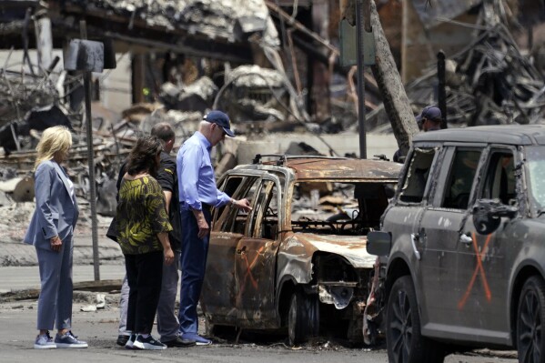 President Joe Biden and first lady Jill Biden look at a burned car with Hawaii Gov. Josh Green and his wife Jaime Green as they visit areas devastated by the Maui wildfires, Monday, Aug. 21, 2023, in Lahaina, Hawaii. (AP Photo/Evan Vucci)