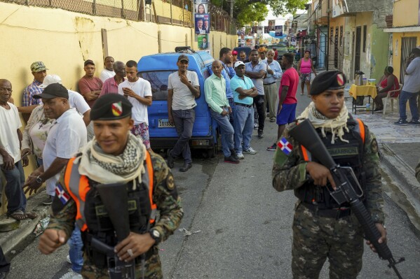 Voters line up outside a polling station during general elections in Santo Domingo, Dominican Republic, Sunday, May 19, 2024. (AP Photo/Ricardo Hernandez)