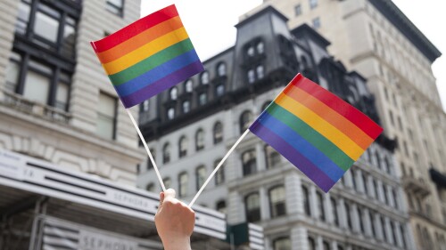 FILE - An attendee holds up flags during the New York City Pride Parade, June 24, 2018, in New York. Members of an LGBTQ+ group are calling on the mayor of a southern Minnesota city to meet their demands — or resign — after he asked pastors at a church holding a Pride event if there would be stripper poles in the sanctuary and posted a public prayer alluding to “sin and brokenness” at the event. (AP Photo/Steve Luciano, File)