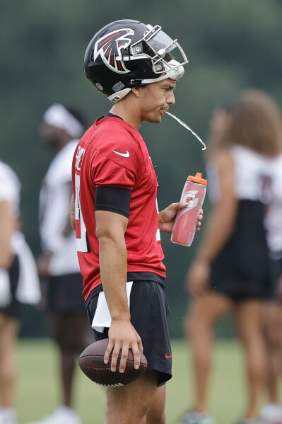 Atlanta Falcons quarterback Desmond Ridder (9) spits after taking a drink of water during the NFL football team's training camp, Saturday, July 29, 2023, in Flowery Branch, Ga. (AP Photo/Alex Slitz)