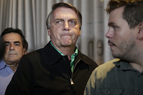 FILE - Brazil's former President Jair Bolsonaro prepares to speak to the press in Belo Horizonte, Brazil, June 30, 2023, the day that judges ruled him ineligible to run for any political office again until 2030 after concluding that he abused his power and cast unfounded doubts on the country's electronic voting system. According to a Federal Police indictment unveiled Tuesday, March 19, 2024, Bolsonaro turned to an aide-de-camp and asked him to insert false data into the public health system to make it appear as though he and his daughter had received the COVID-19 vaccine, in order to have the necessary vaccination certificate required by U.S. authorities for their 2023 trip to Florida. (AP Photo/Thomas Santos, File)