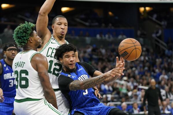 Orlando Magic's Chuma Okeke, right, passes the ball as he gets caught between Boston Celtics' Marcus Smart (36) and Grant Williams (12) during the second half of an NBA basketball game, Saturday, Oct. 22, 2022, in Orlando, Fla. (AP Photo/John Raoux)