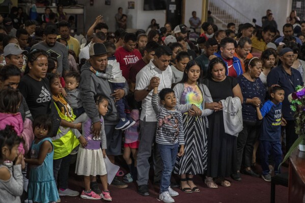 Mexican migrants, many from Michoacan state, attend a religious service at the "Embajadores de Jesus" Christian migrant shelter in Tijuana, Mexico, Tuesday, Sept. 26, 2023. While many places in Mexico provide shelter for migrants from other countries, some shelters in Tijuana have seen an influx of Mexicans fleeing violence, extortion and threats by organized crime. (AP Photo/Karen Castaneda)