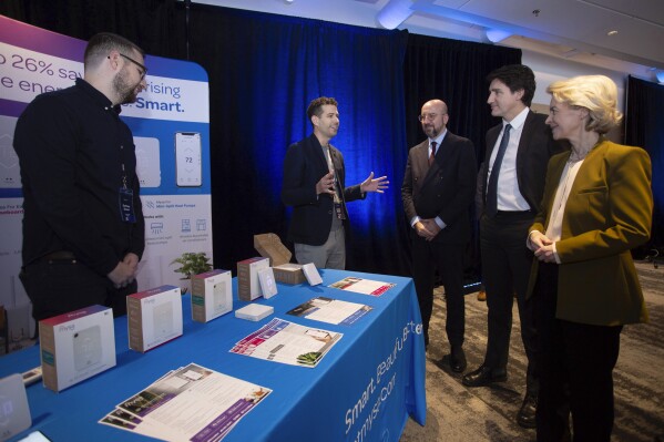 Brothers Zachary Green, from left, and Joshua Green, co-founders of MYSA speaks with Charles Michel, President of the European Council, Canada's Prime Minister Justin Trudeau and Ursula von der Leyen, President of the European Commission, at the Genesis Demonstration Fair at the Emera Innovation Exchange during the Canada-EU Summit in St. John's, Newfoundland and Labrador, on Friday, Nov. 24, 2023. (Paul Daly/The Canadian Press via AP)