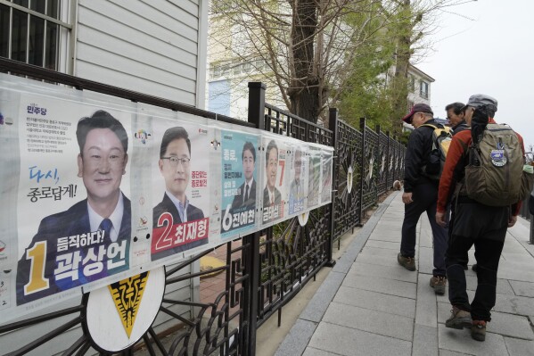 People pass by posters of candidates running for the upcoming parliamentary election in Seoul, South Korea, Wednesday, April 3, 2024. As South Koreans prepare to vote for a new 300-member parliament next week, many are choosing their livelihoods and other domestic topics as their most important election issues. This represents a stark contrast from past elections, which were overshadowed by security and foreign policy issues like North Korean nuclear threats and the U.S. security commitment.(AP Photo/Ahn Young-joon)