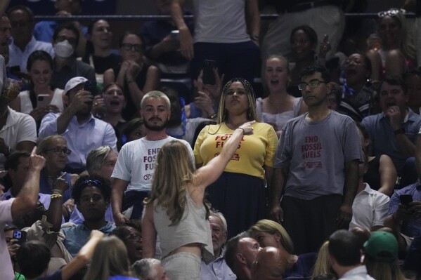 An audience member yells at protesters as they demonstrate at a match between Coco Gauff, of the United States, and Karolina Muchova, of the Czech Republic, during the women's singles semifinals of the U.S. Open tennis championships, Thursday, Sept. 7, 2023, in New York. (AP Photo/Frank Franklin II)