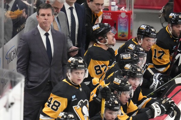 Pittsburgh Penguins head coach Mike Sullivan, left, stands behind his bench during the first period of an NHL hockey game against the New York Islanders in Pittsburgh, Tuesday, Feb. 20, 2024. (APPhoto/Gene J. Puskar)