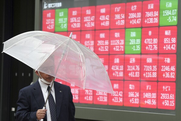 FILE - A person walks in front of an electronic stock board showing Japan's Nikkei 225 index at a securities firm in Tokyo, on April 22, 2024. Asian stocks fell Wednesday, May 1, 2024 with most of the markets in the region closed for a holiday. Meanwhile, U.S. stocks closed out their worst month since September. (AP Photo/Eugene Hoshiko, File)