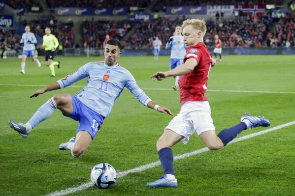 Spain's Ferran Torres, left, and Norway's Birger Meling fight for the ball during the Euro 2024 group A qualifying soccer match between Norway and Spain at the Ullevaal Stadium in Oslo, Norway, Sunday Oct. 15, 2023. (Emilie Holtet/NTB Scanpix via AP)