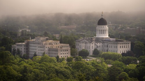 FILE - The morning fog lifts beyond the Burton M. Cross Building, left, and the State House, Wednesday, June 21, 2023, in Augusta, Maine. Maine lawmakers are meeting ,Thursday, July 6, 2023, for votes to enact a bill expand access to abortions and to override a bill to allow more federal laws to apply to Native American tribes in the State. (AP Photo/Robert F. Bukaty, File)