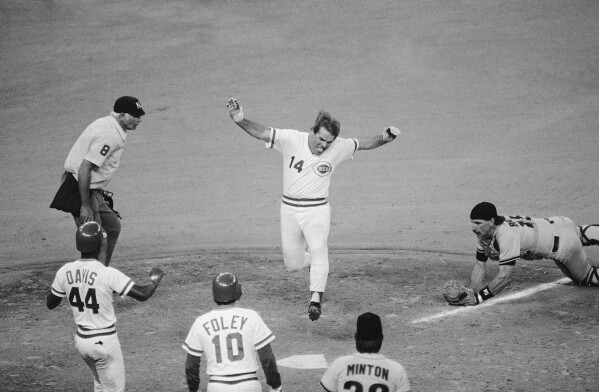 Cincinnati Reds player-manager Pete Rose leaps onto home plate as he scores the winning run in the 10th inning of a baseball game against the San Francisco Giants at Riverfront Stadium in Cincinnati, April 19, 1985. (AP Photo/Al Behrman, File)