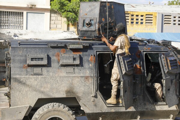 Police take cover during an anti-gang operation in Port-au-Prince, Haiti, Friday, March 1, 2024. (AP Photo/Odelyn Joseph)