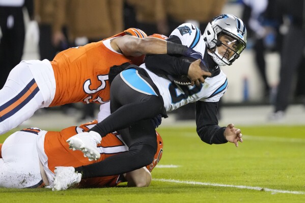 Carolina Panthers quarterback Bryce Young (9) is tackled by Chicago Bears linebacker T.J. Edwards (53) during the first half of an NFL football game Thursday, Nov. 9, 2023, in Chicago. (AP Photo/Charles Rex Arbogast)