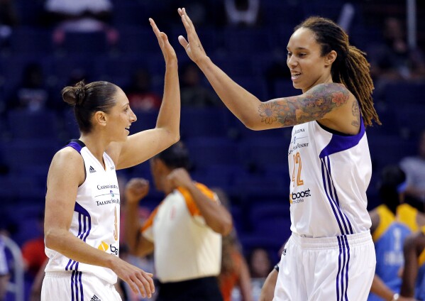 FILE - Phoenix Mercury guard Diana Taurasi, left, high-fives teammate Brittney Griner during the first half of a WNBA basketball game against the Chicago Sky, on July 2, 2014, in Phoenix. Five-time Olympic gold medalist Diana Taurasi and Brittney Griner head up the USA Basketball Women’s National Team roster of 16 players announced Thursday, Oct. 26, 2023, for a pair of November exhibition games and training camp in Atlanta.(AP Photo/Matt York, File)