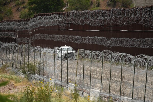 FILE - A vehicle drives along the U.S. side of the US-Mexico border wall in Nogales, Ariz. on Tuesday, June 25, 2024. (AP Photo/Jae C. Hong, Pool)