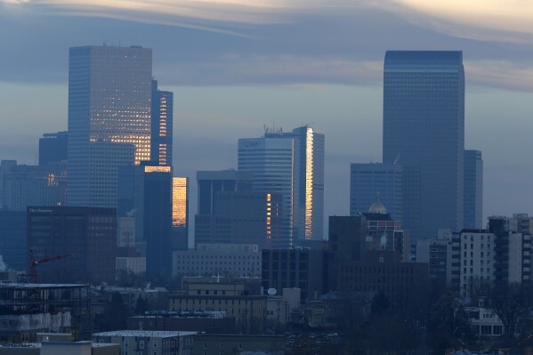 FILE - Pollution obscures the skyline of downtown as the sun rises over Denver, on Feb. 28, 2019. The Environmental Protection Agency is delaying plans to tighten air quality standards for ground-level ozone — better known as smog — despite a recommendation by a scientific advisory panel to lower air pollution limits to protect public health. (AP Photo/David Zalubowski, File)