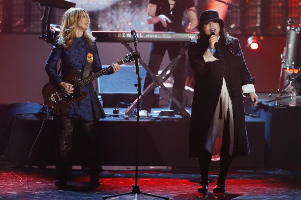 FILE - Nancy Wilson, left, and Ann Wilson, right, of the band Heart perform as Heart is inducted into the Rock and Roll Hall of Fame during the Rock and Roll Hall of Fame Induction Ceremony at the Nokia Theatre on Thursday, April 18, 2013 in Los Angeles. Heart — the pioneering band that melds Nancy Wilson’s shredding guitar with her sister Ann’s powerhouse vocals — is hitting the road this spring for a world tour that Nancy Wilson describes as “the full-on rocker size.” (Photo by Danny Moloshok/Invision/AP, File)
