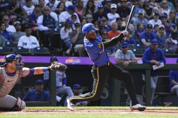 Seattle Mariners' Victor Robles, right, hits the ball for a foul during the first inning of a game against the New York Mets, Sunday, Aug. 11, 2024, in Seattle. (AP Photo/Liv Lyons)