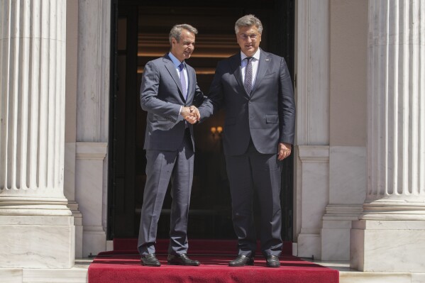 Greece's Prime Minister Kyriakos Mitsotakis, left, welcomes his Croatian counterpart Andrej Plenkovic before their meeting at Maximou mansion, in Athens, on Monday, Aug. 21, 2023.(AP Photo/Petros Giannakouris)